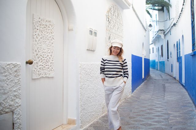 woman walking down the street in the old town of asilah, morocco