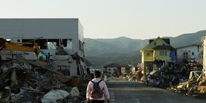 a woman walks in a stricken area that was devastated by the