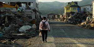 a woman walks in a stricken area that was devastated by the