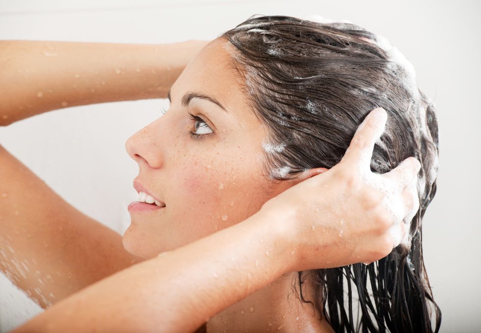 woman washing her hair with shampoo under the shower xxxl