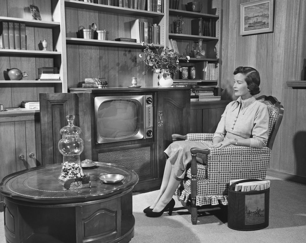 woman watching tv in wood paneled room
