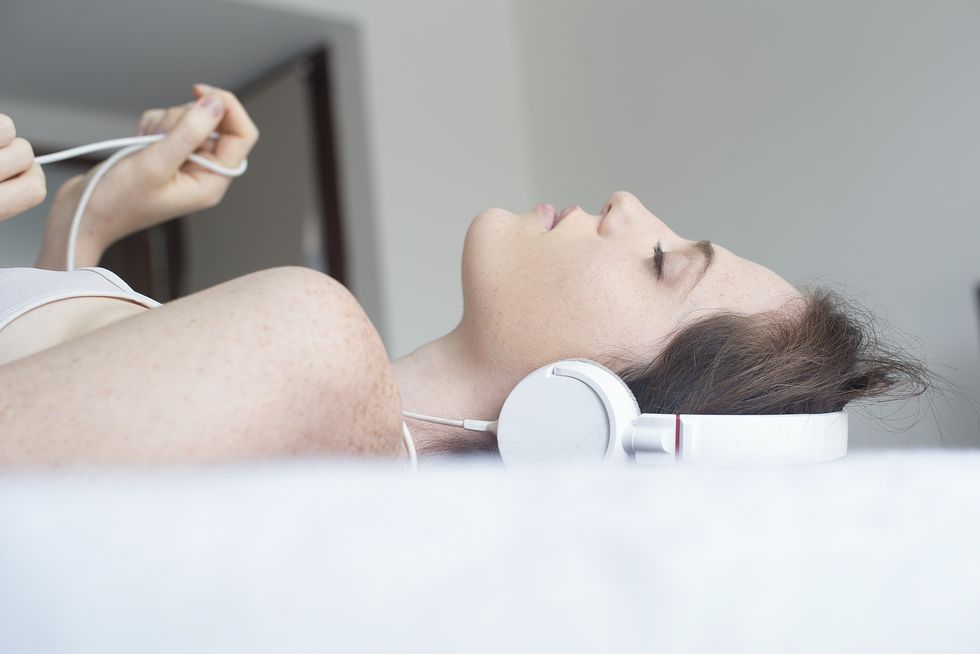 woman wearing headphones lying down