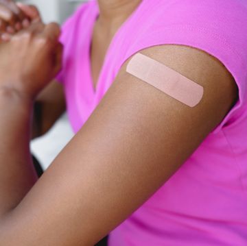 woman wears adhesive bandage on upper arm