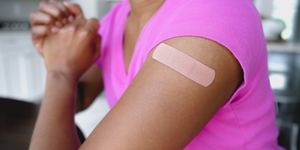 woman wears adhesive bandage on upper arm