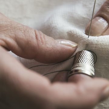 mujer cosiendo con un dedal
