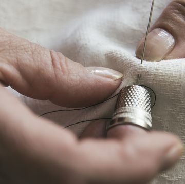 mujer cosiendo con un dedal