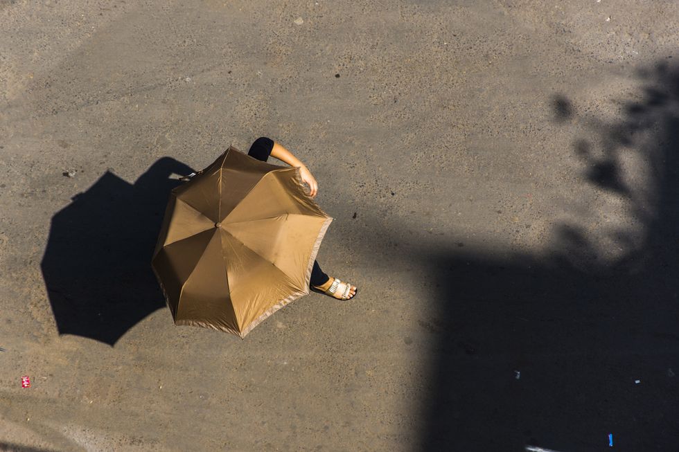 a woman with an umbrella on a sunny day from above