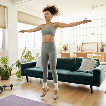 woman with arms outstretched exercising at home