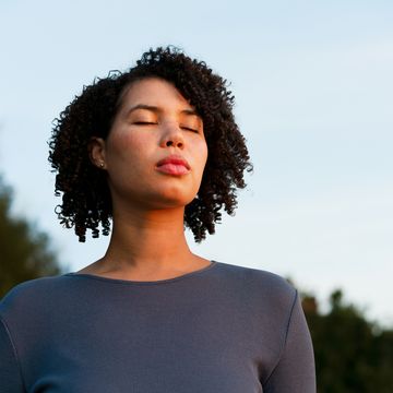 woman with eyes closed at dusk