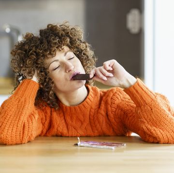 vrouw eet een stuk chocolade