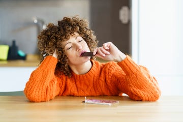 vrouw eet een stuk chocolade