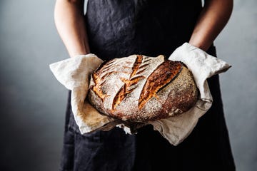 woman with fresh baked sourdough bread in kitchen