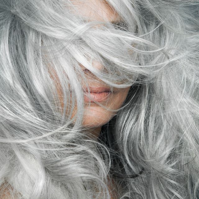 woman with grey hair blowing across her face
