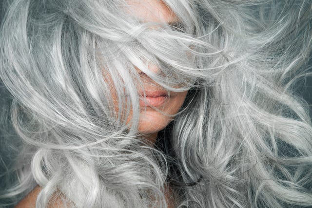 woman with grey hair blowing across her face