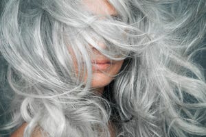 woman with grey hair blowing across her face