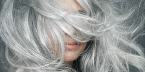 woman with grey hair blowing across her face