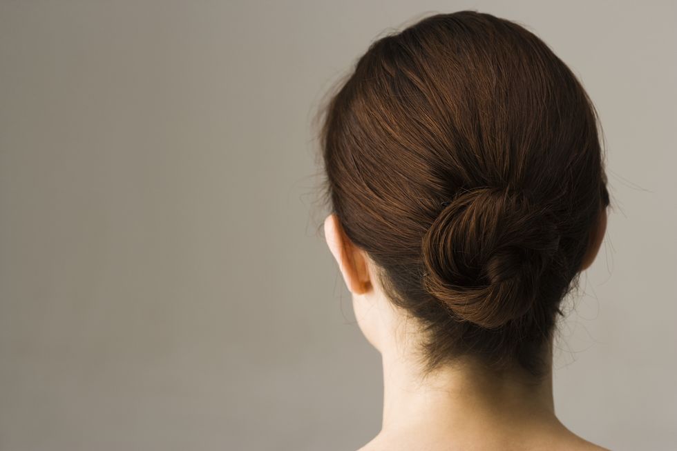Woman with hair arranged in chignon, rear view