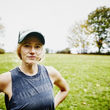 Woman with hair blowing in wind in park after run