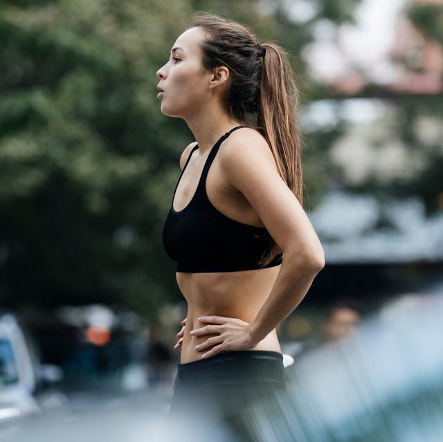 woman with hands on hips resting after exercise