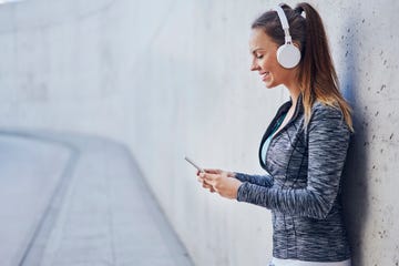 woman with headphones using smartphone