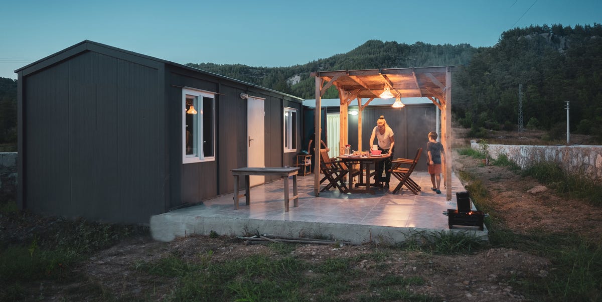 woman with her son preparing dinner table for bbq on patio of alternative container house