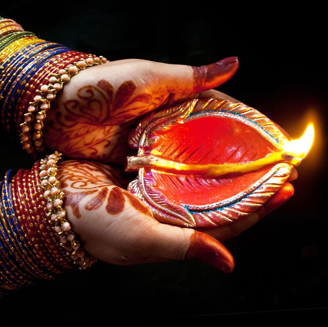 woman with lit earthen lamp at diwali festival