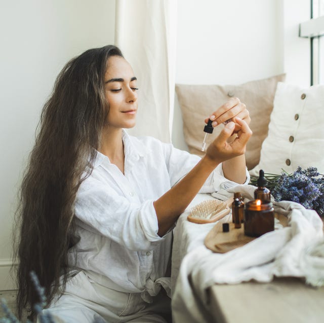 woman with long hair using serum for hair loss treatment