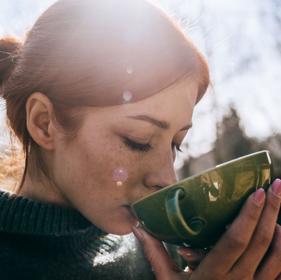 woman with red hair drinking tea outdoor