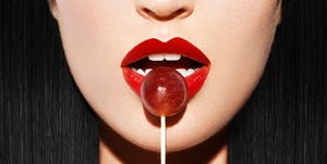 woman with red lips holding lollipop