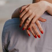 woman with red nails hugs man