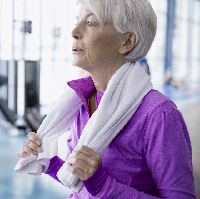 Woman with towel resting at gym