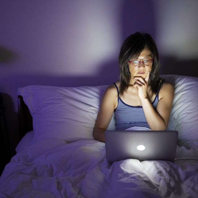 woman working late on laptop in bed