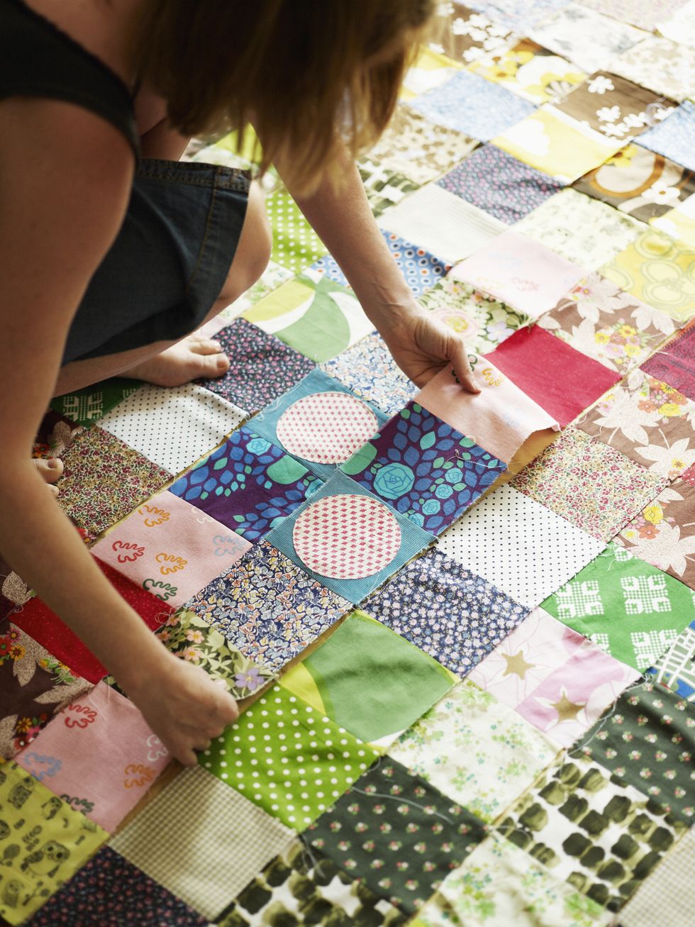 woman working on patches to make quilt