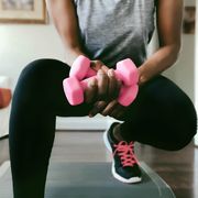 woman works out with dumbells at home