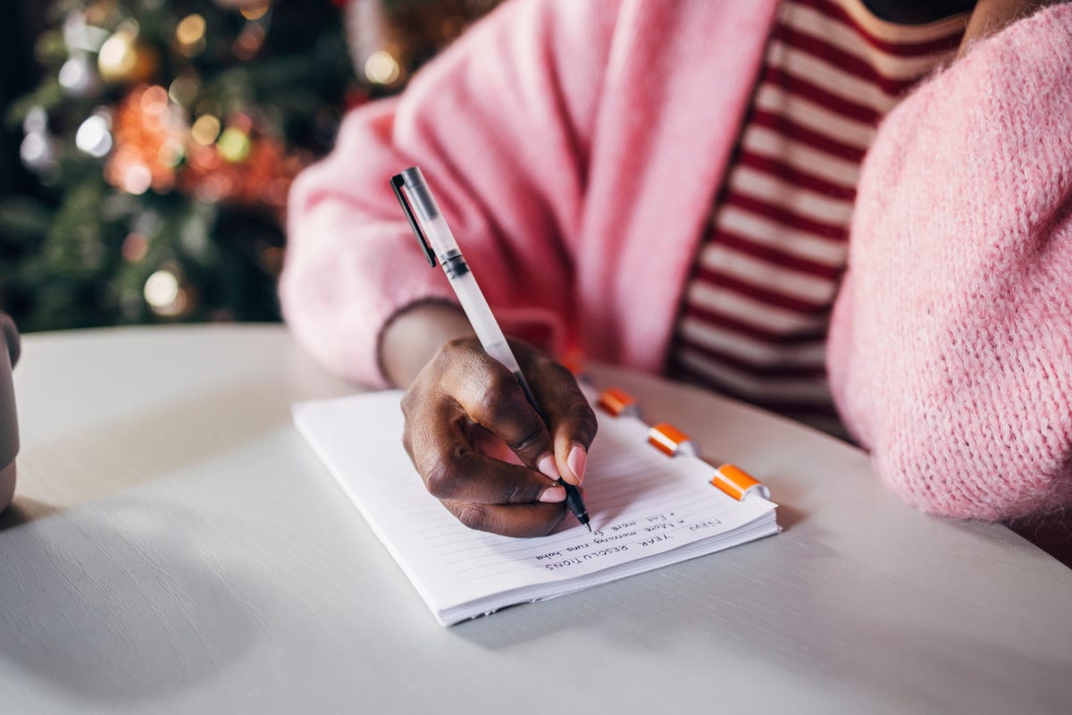 woman writing new year's resolutions