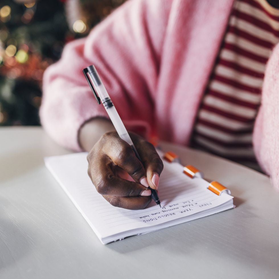 woman writing new year's resolutions