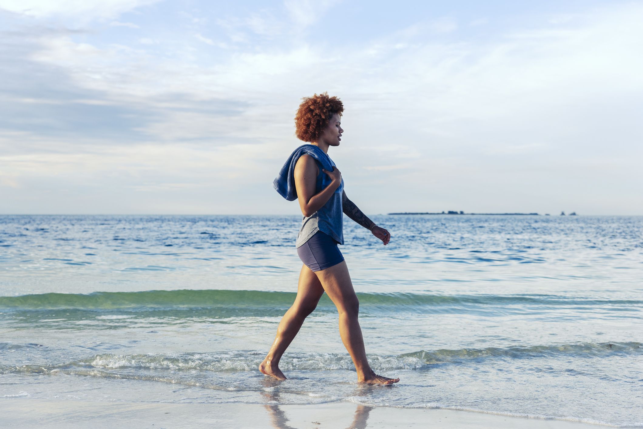 Female Fitness Trainer on the sand beach sunset background