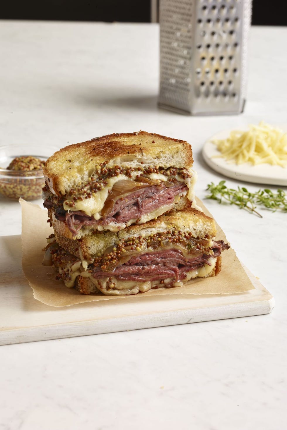 roast beef and french onion grilled cheese sandwich on a piece of parchment paper