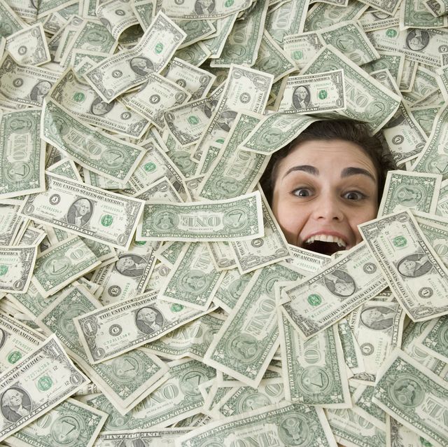 woman's face peeking out of a pile of money