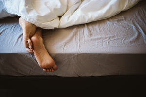 a woman's feet in bed under the blanket