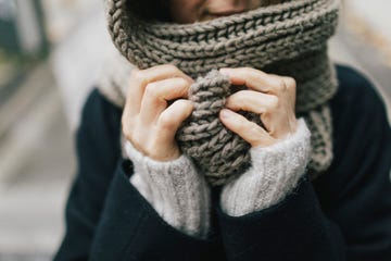 woman's hand holding knitted scarf, close up