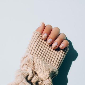 woman's hand in warm sweater showing manicure