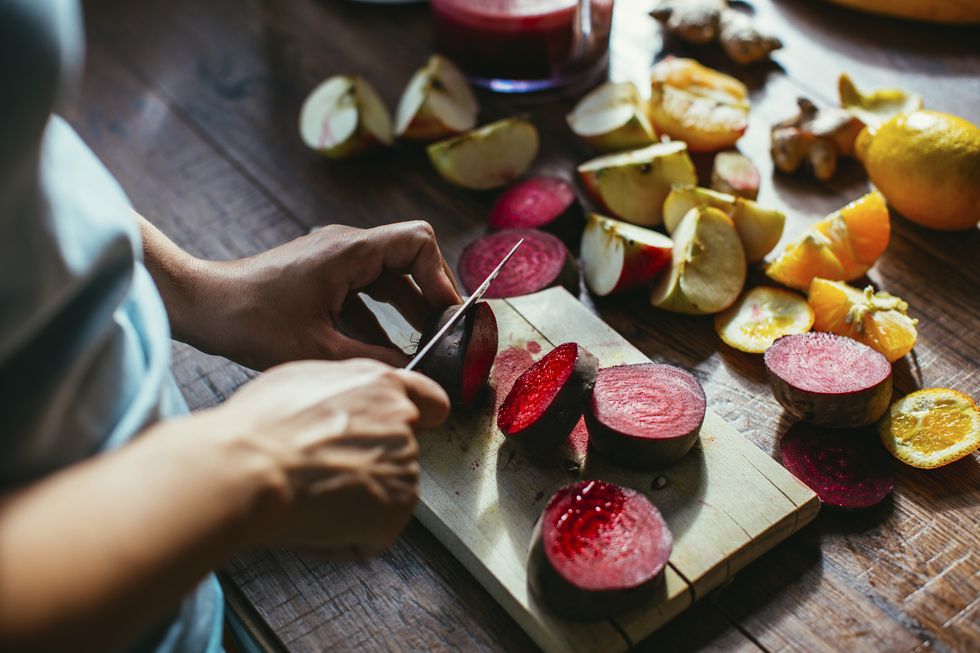womans hands chopping beetroot for squeezing juice