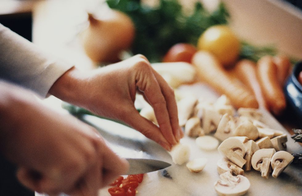 Woman's hands chopping up vegetables in kitchen, close-up