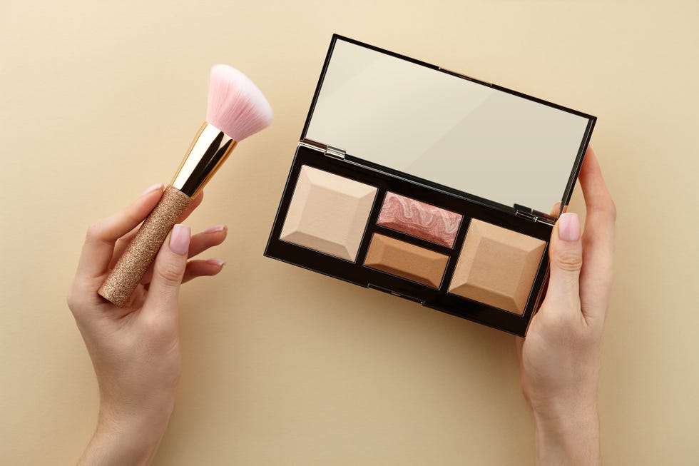 Woman's hands holding make up palette and brush