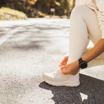 woman's hands tying shoes before running or jogging outdoors