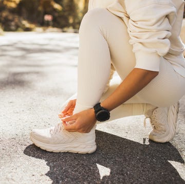 woman's hands tying shoes before running or jogging outdoors