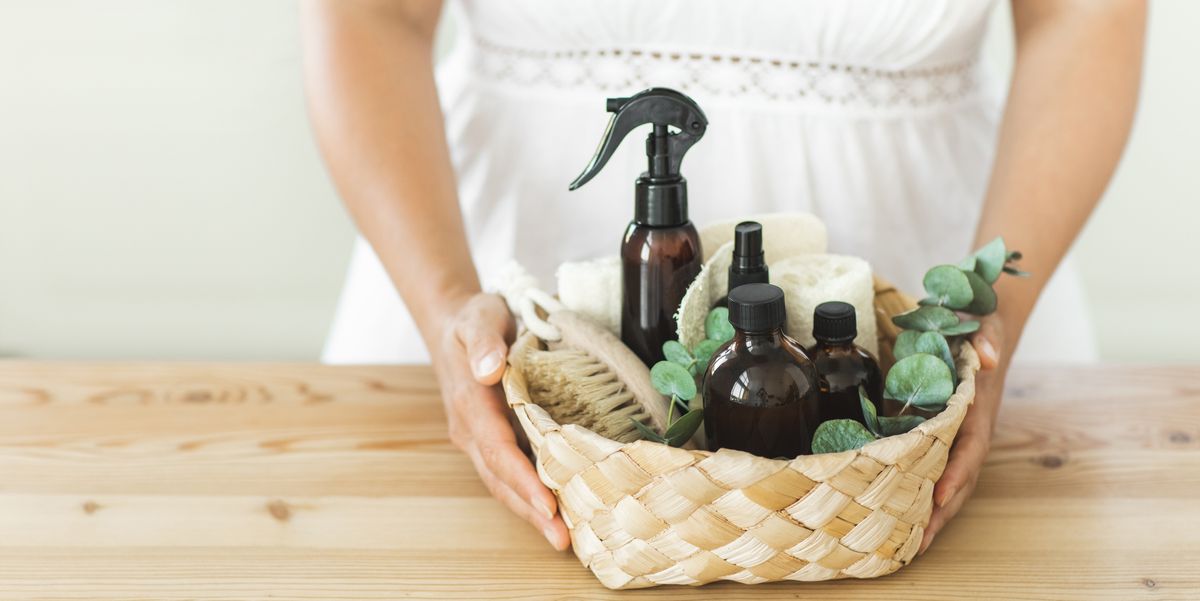 woman's hands with basket with various items and ingredients for eco home cleaning and house plants