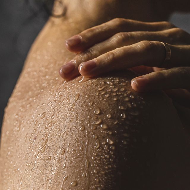 woman's shoulder with hand on shower