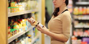 women choosing a dairy products at supermarket reading product information